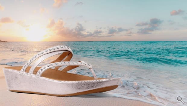 Rosafarbene mit Strasssteinchen verzierte Fitflop Pantolette -Linny Criss Cross- vor Sonnenuntergang am Strand.